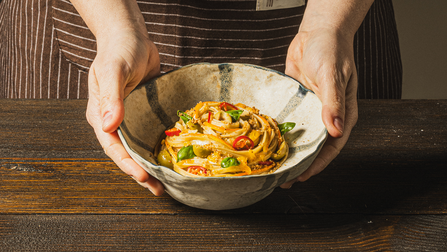 Fettuccine alle olive verdi, arancia e basilico con briciole di pane al peperoncino